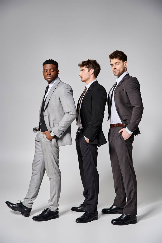 bello elegante multiculturale modelli maschili in business casual abiti in posa su sfondo grigio - Foto, immagini