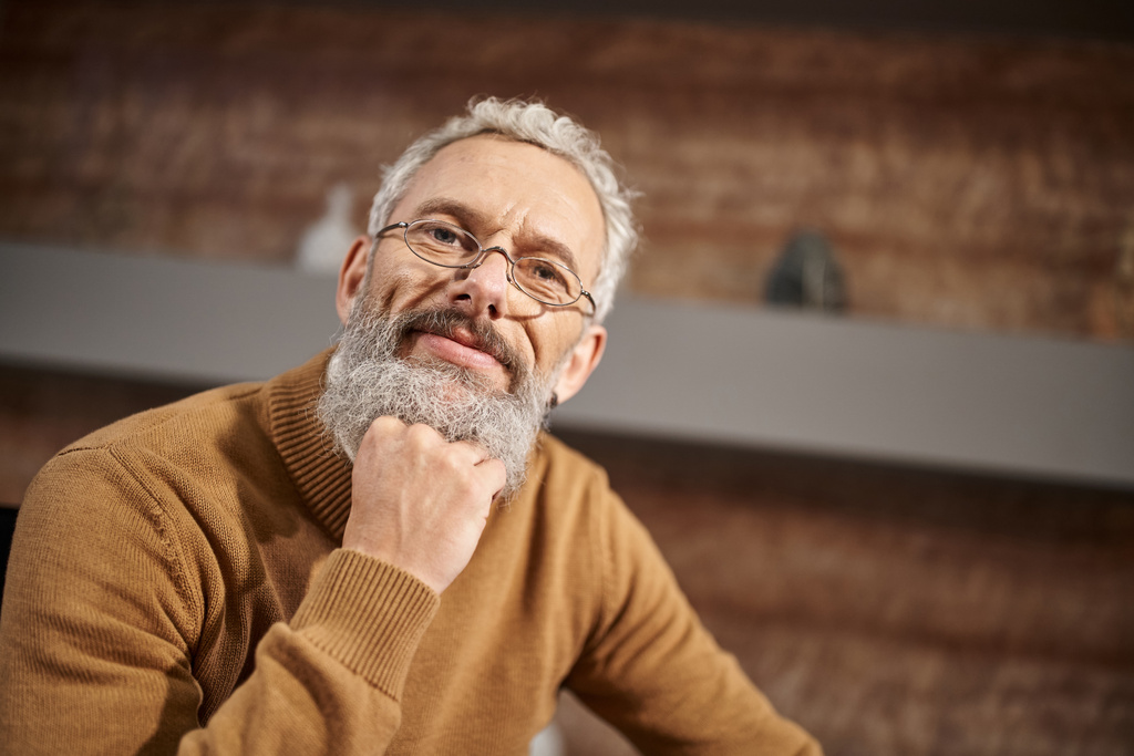 retrato de guapo psicólogo de mediana edad en gafas mirando a la cámara durante la sesión de terapia - Foto, imagen