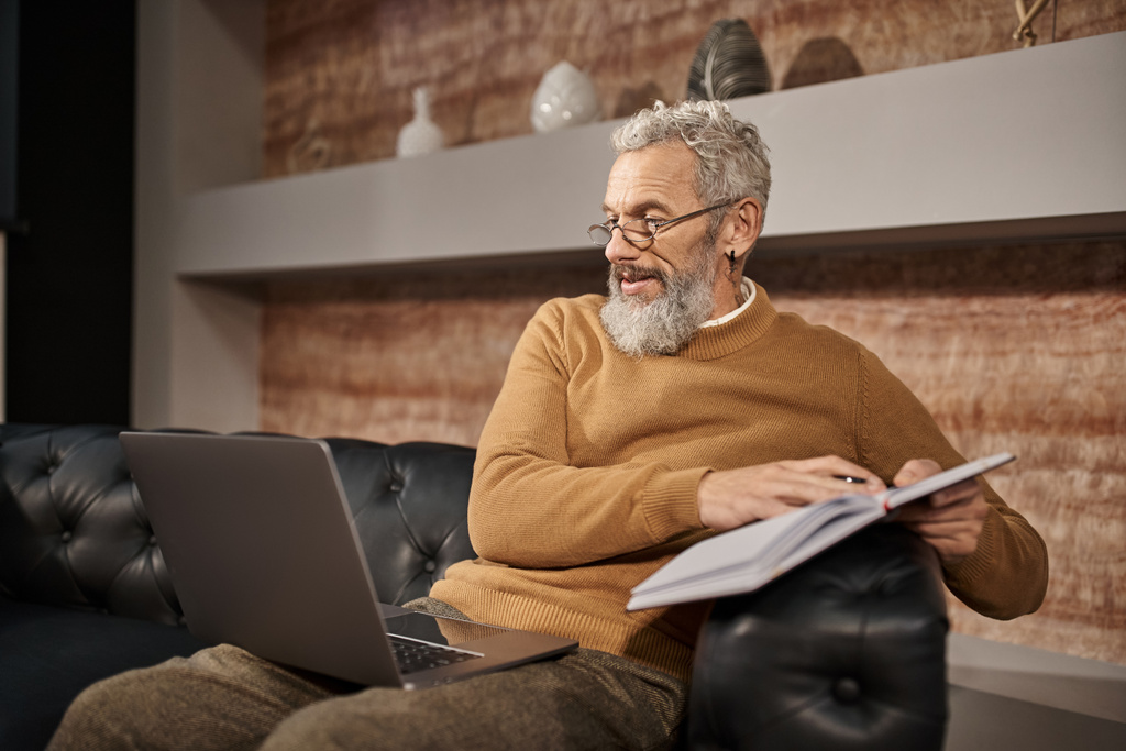 psicólogo barbudo de mediana edad en gafas hablando con el cliente durante la consulta en línea en el ordenador portátil - Foto, Imagen