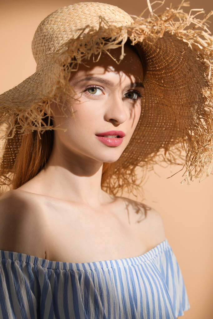 mooie jonge vrouw in zonlicht op beige achtergrond - Foto, afbeelding