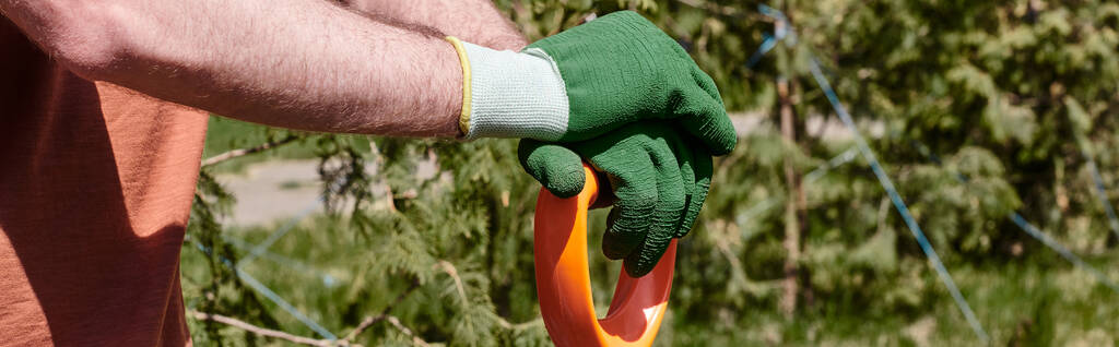 обрезанный вид фермера в перчатках, держащих лопату, стоя на открытом воздухе, баннер ухода за растениями - Фото, изображение