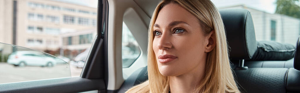 portrait de femme d'affaires blonde confiante voyageant en voiture de luxe sur la rue de la ville, bannière horizontale - Photo, image