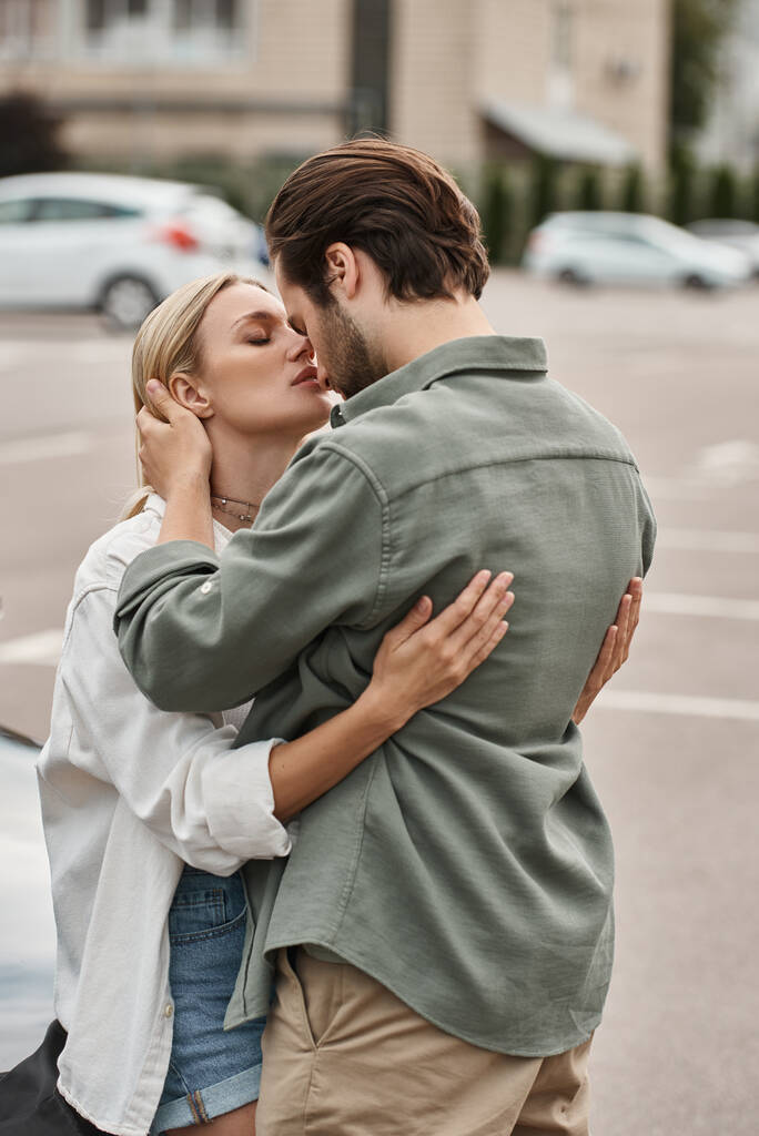 ρομαντικό ζευγάρι σε κομψά casual ρούχα αγκαλιάζει ενώ στέκεται σε αστικό δρόμο, ιστορία αγάπης - Φωτογραφία, εικόνα
