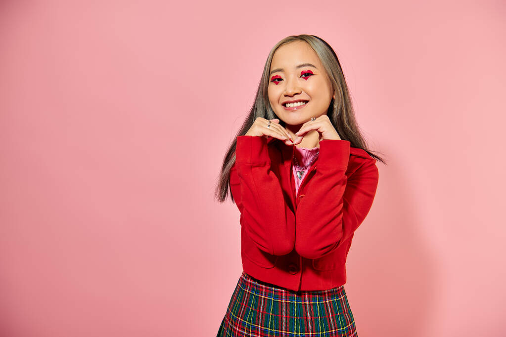 Valentýn, šťastná asijská mladá žena se srdcem make-up ukazující srdce s rukama na růžové - Fotografie, Obrázek