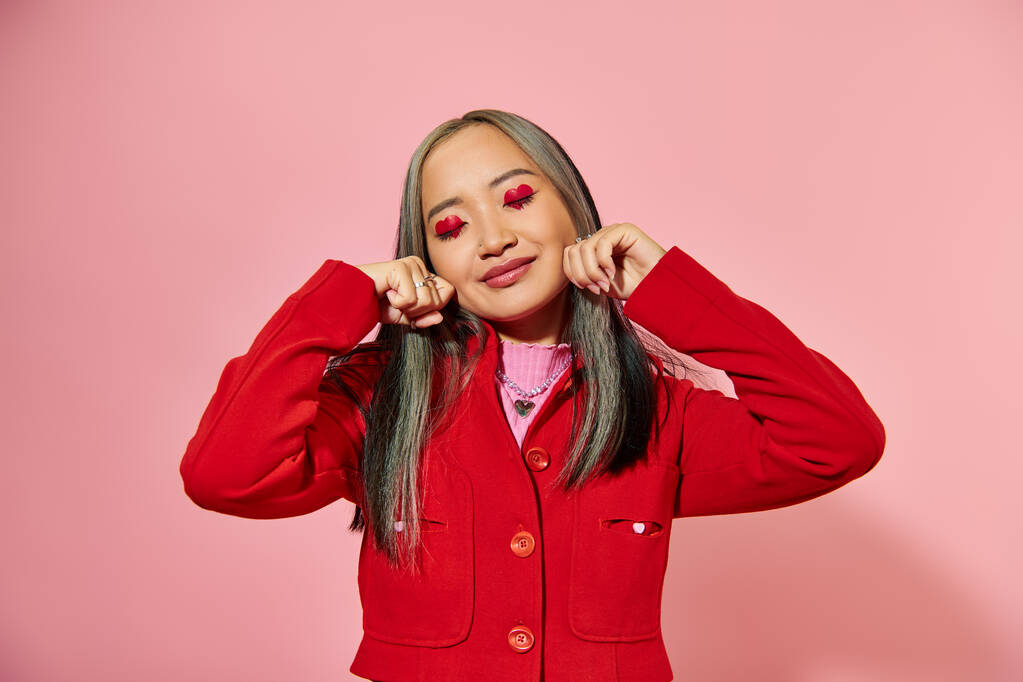 portrét asijské mladé dívky s tvarem srdce oční make-up ukazující pláč gesto na růžovém pozadí - Fotografie, Obrázek