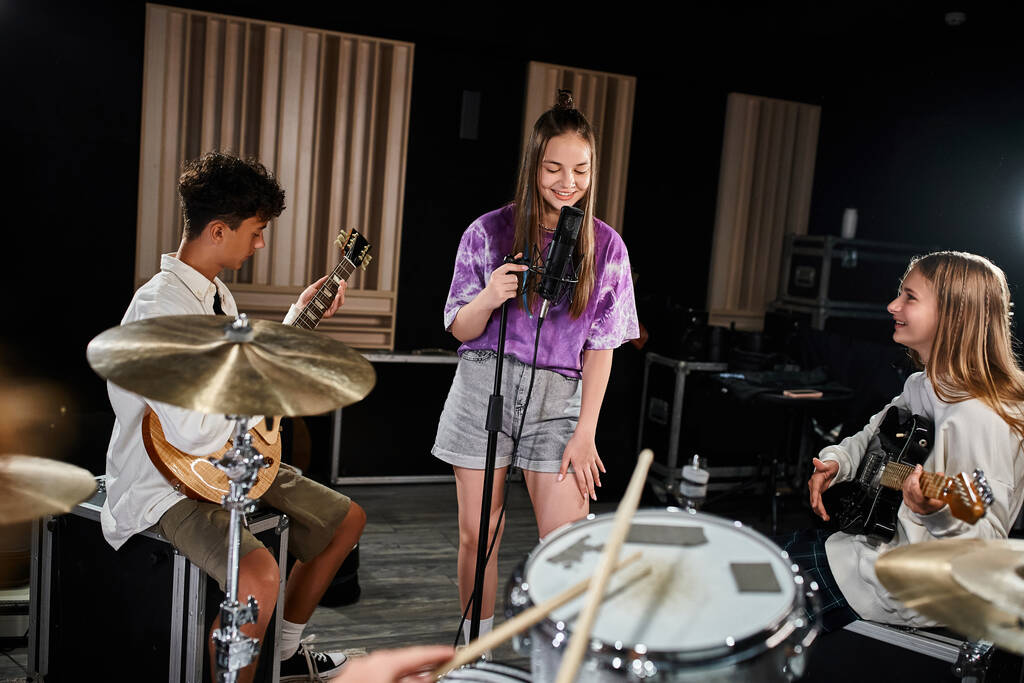 freudig begabte Teenager-Bandmitglieder in lässiger Kleidung, die verschiedene Instrumente singen und spielen - Foto, Bild