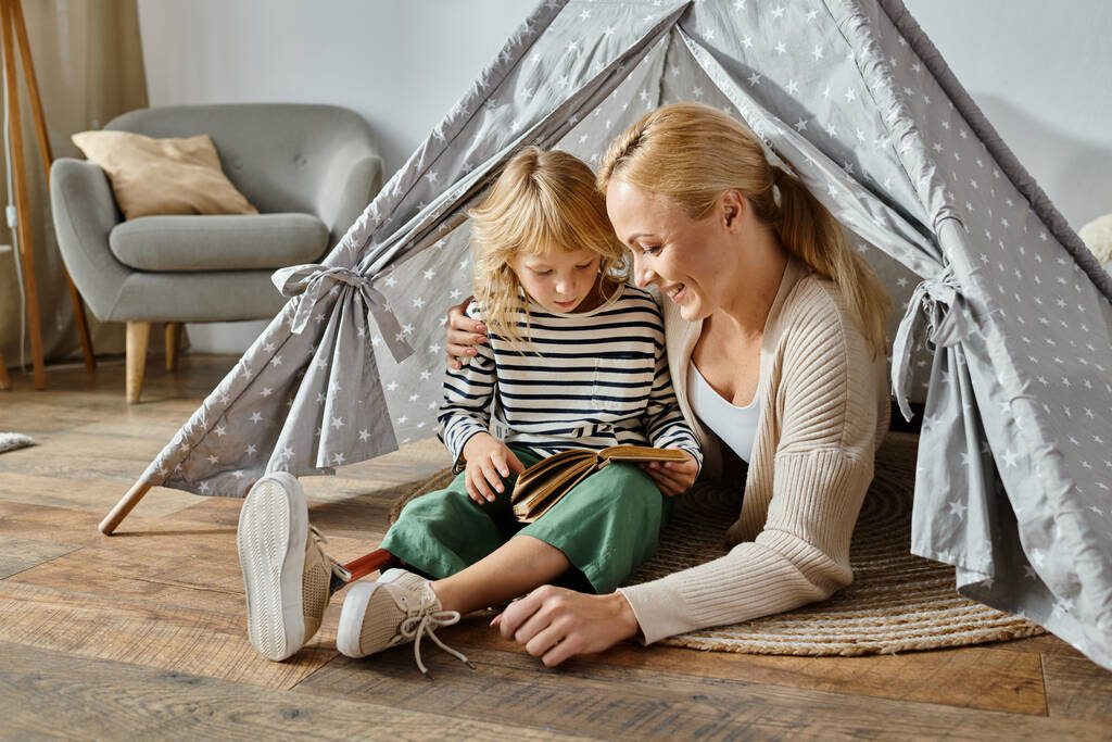 かわいい 女の子 ととも に 義足 読書 本 と 幸せ 母 と 座っ 自宅 遊び テント - 写真・画像