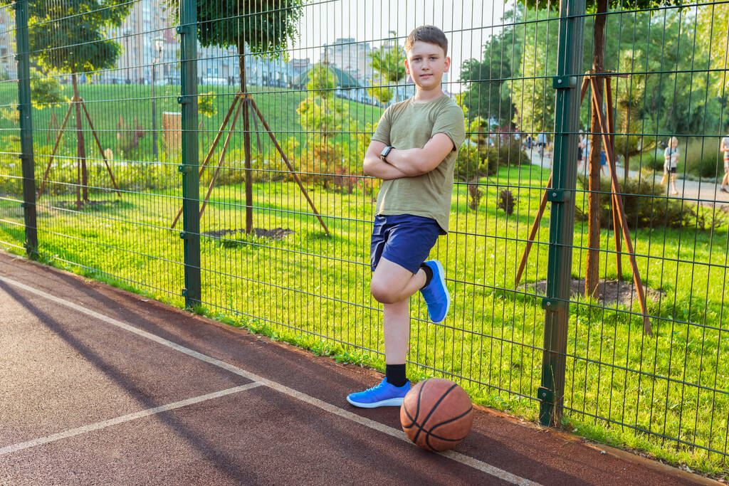 Adolescente en una cancha de baloncesto en un día soleado. - Foto, imagen