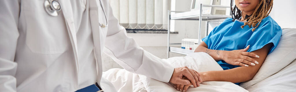 medico indiano che tiene la mano del paziente afro-americano sdraiato nel letto d'ospedale, ritagliato, striscione - Foto, immagini