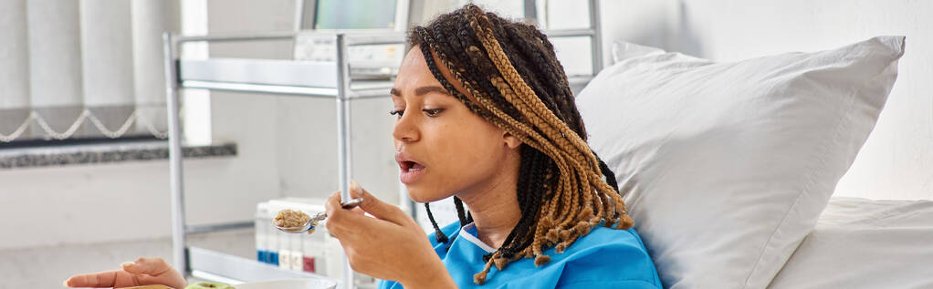 若いアフリカ系アメリカ人女性は,彼女の病院区で朝食のためにお粥とリンゴを持っています, バナー - 写真・画像