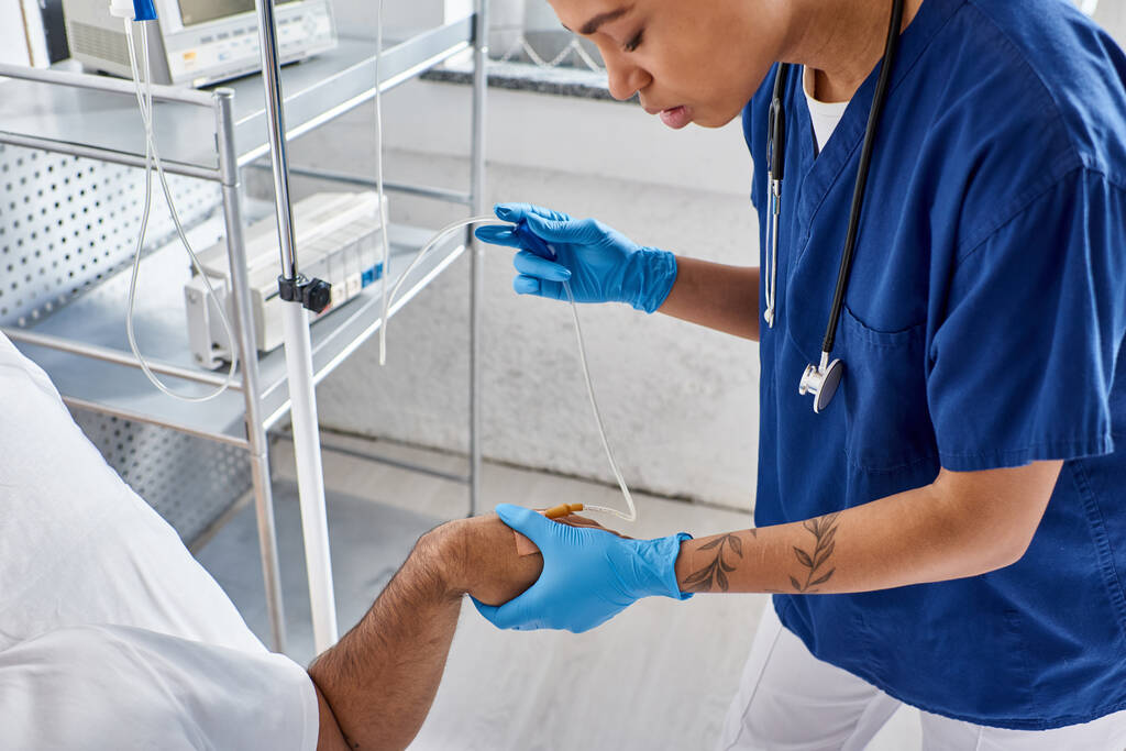 bijgesneden beeld van Afrikaans-Amerikaanse verpleegster zetten drop counter voor haar Indiase patiënt, gezondheidszorg - Foto, afbeelding