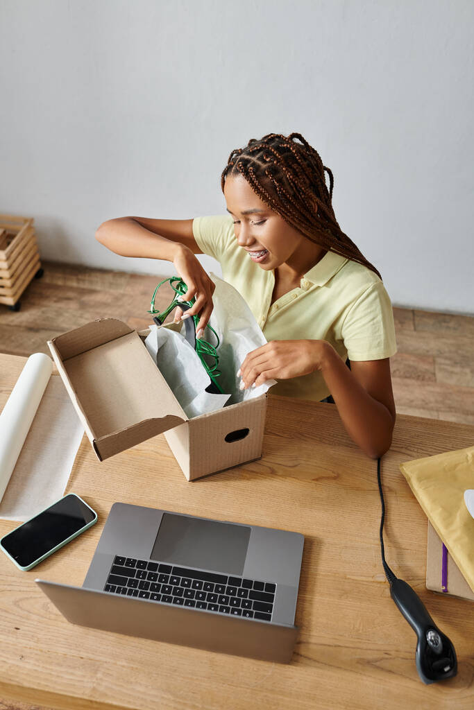 jolly jong Afrikaans amerikaanse vrouw retailer verpakking groene schoenen in doos, levering concept - Foto, afbeelding