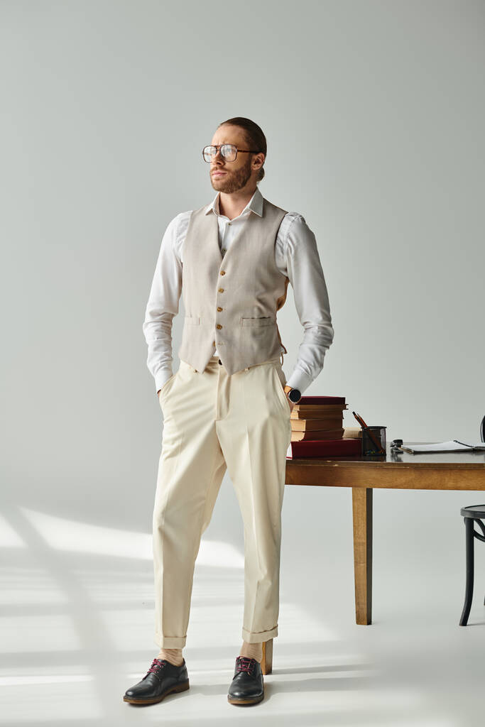 schöner eleganter Mann mit Brille in stylischer Kleidung posiert mit den Händen in den Taschen und schaut weg - Foto, Bild