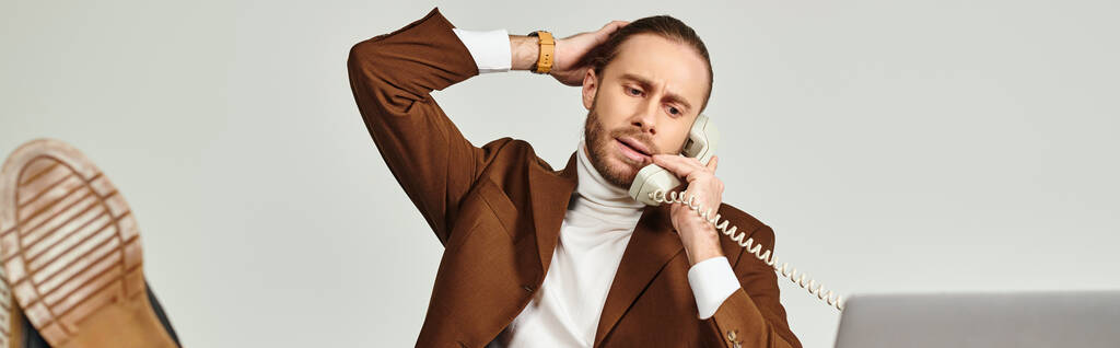 csinos férfi szakállal elegáns öltönyben beszél retro telefon lábakkal az asztalon, banner - Fotó, kép