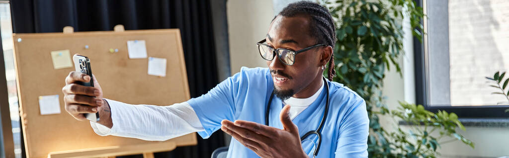 gericht Afrikaans-Amerikaanse arts met bril consultancy patiënt via mobiele telefoon, telegezondheid, banner - Foto, afbeelding