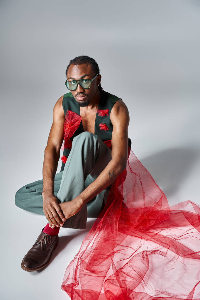 good looking african american male model with sunglasses in fashionable attire sitting on floor - Photo, Image