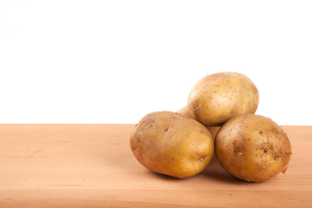 Quatre pommes de terre sur table en bois
 - Photo, image