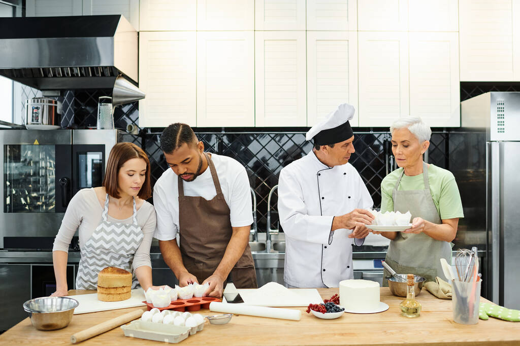 красивые мультикультурные люди с фартуками выпечки вкусный торт с их шеф-поваром, кулинарные курсы - Фото, изображение