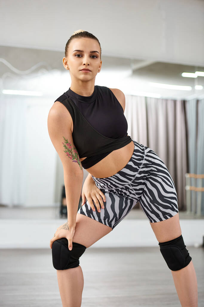 balancierte Frau in einem Oberteil und Zebra-Shorts anmutig bewegten Gliedmaßen und Oberkörper in einem choreographierten Tanz - Foto, Bild