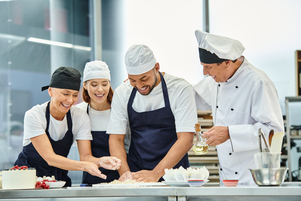 alegres chefs de boa aparência trabalhando com massa juntos ao lado de seu chefe cozinheiro, confeitaria - Foto, Imagem