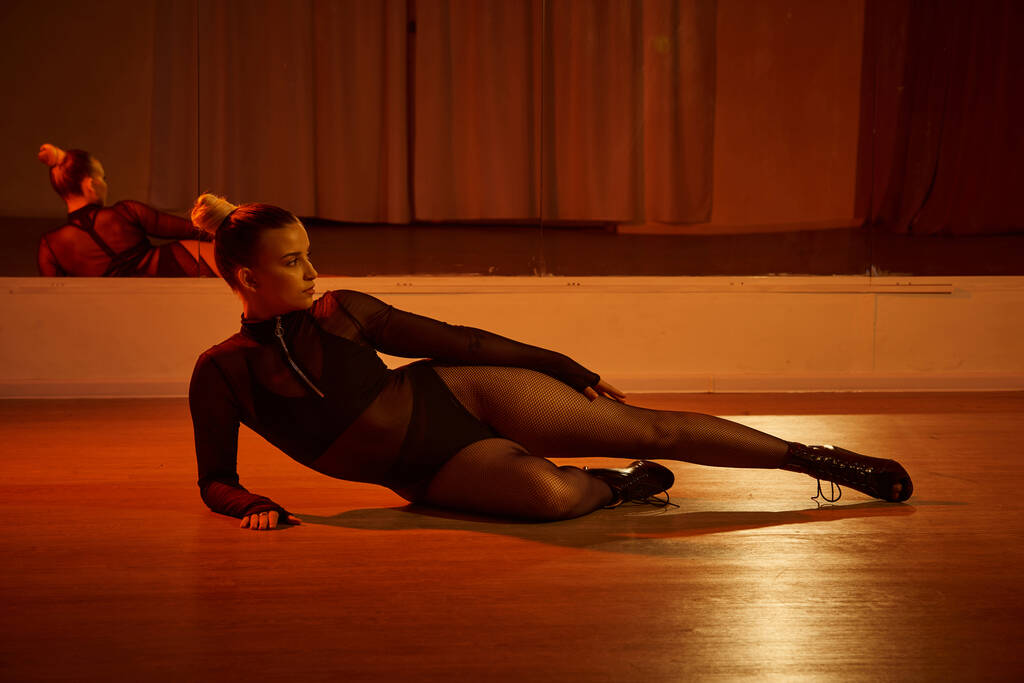 Eine talentierte Person in High Heels posiert anmutig auf der Tanzfläche im Studio, fesselnde Szene - Foto, Bild