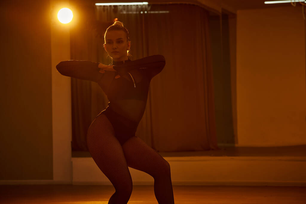 sierlijke danser glijdt door de kamer, vrouw voert een complexe choreografie met perfecte balans - Foto, afbeelding