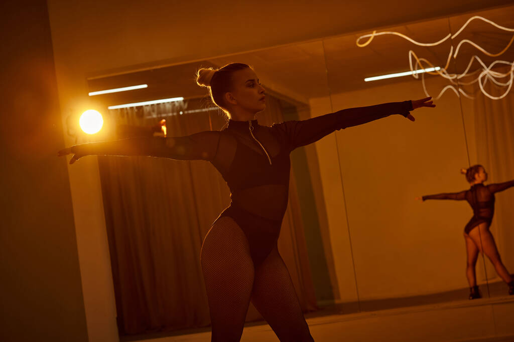 Una graziosa ballerina in body, che trasuda forza e passione nel suo sport indoor di danza - Foto, immagini