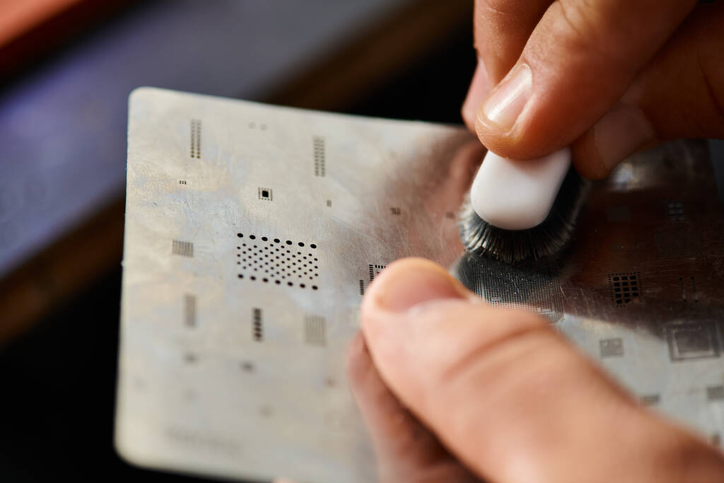 zblízka pohled na zkušený technik čištění mikroschéma se štětcem při práci v dílně - Fotografie, Obrázek