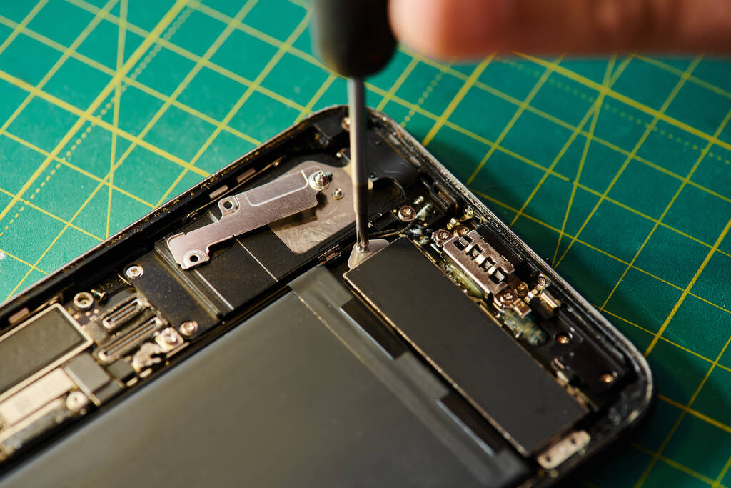zugeschnittene Ansicht von qualifizierten Reparateur Montage repariert Smartphone in der Werkstatt, Kleinunternehmen - Foto, Bild