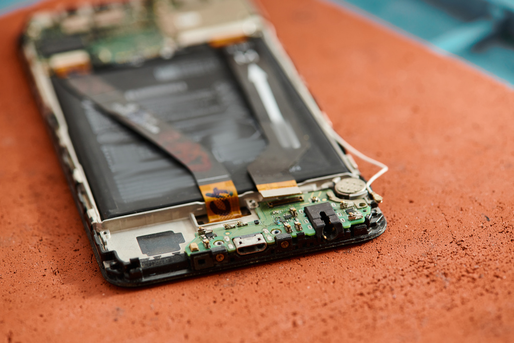 vista de perto do smartphone quebrado desmontado na mesa na oficina de reparação de equipamentos, manutenção - Foto, Imagem