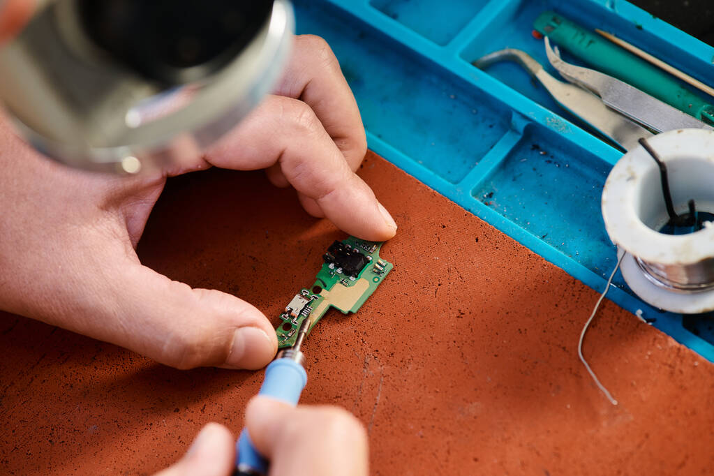 gewas weergave van technische specialist solderen microregeling in reparatiewerkplaats, onderhoud - Foto, afbeelding