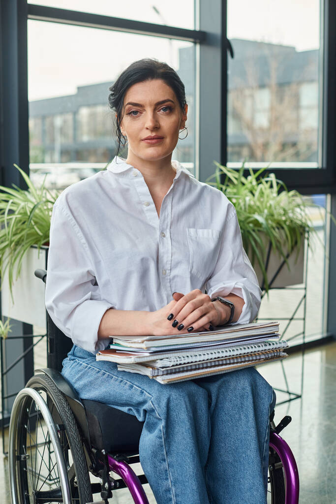 attractive devoted businesswoman in stylish attire in wheelchair looking straight at camera - Photo, Image