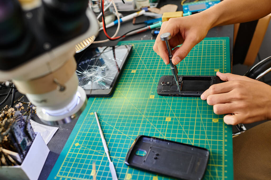 μερική άποψη του επαγγελματία τεχνικού με κατσαβίδι επισκευή κινητού τηλεφώνου σε ιδιωτικό εργαστήριο - Φωτογραφία, εικόνα