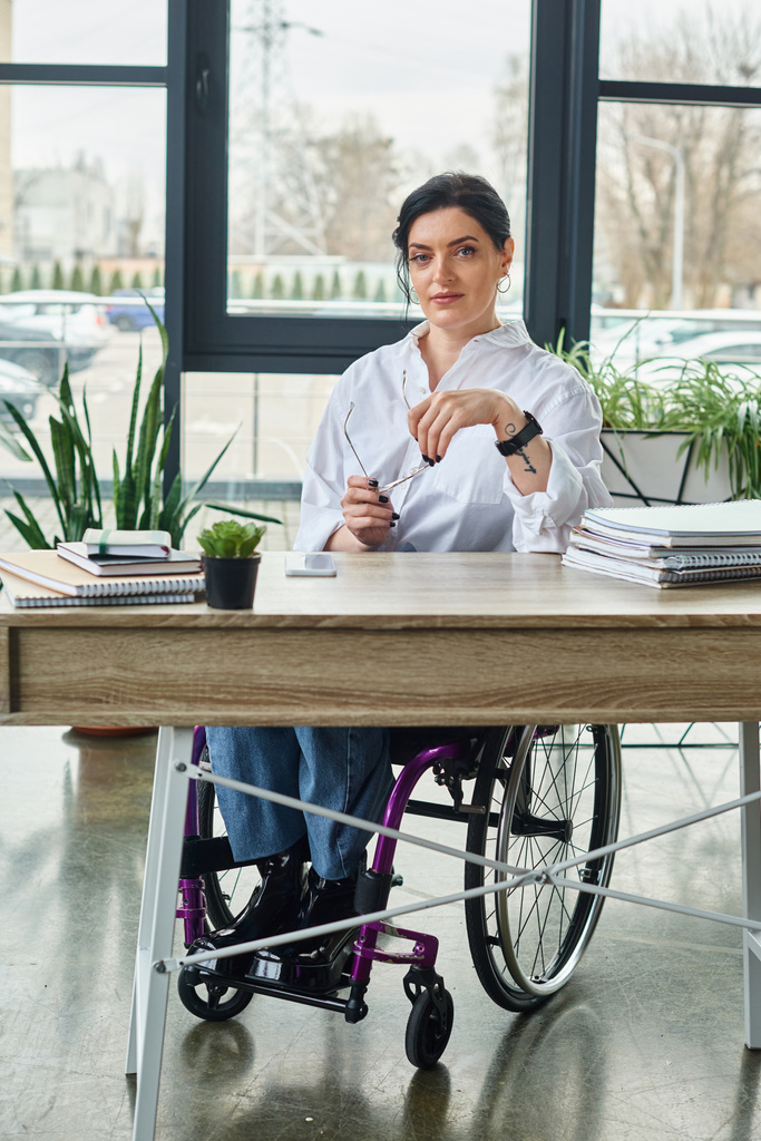 good looking confident businesswoman with disability in wheelchair with glasses looking at camera - Photo, Image