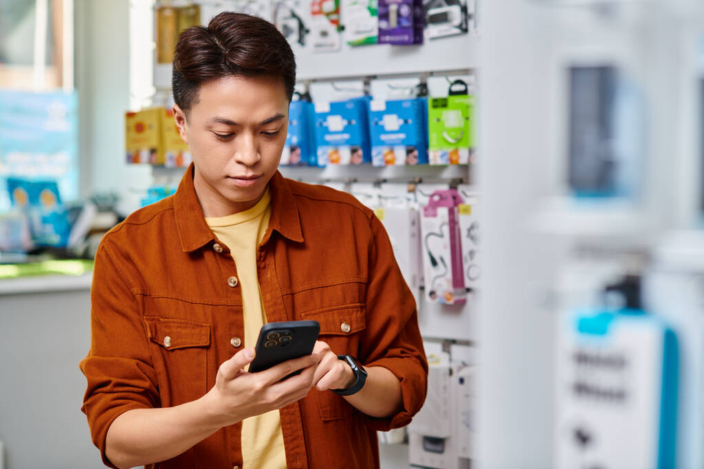 Азиатская электроника судовладелец сообщение на мобильный телефон в торговых помещениях, концепция малого бизнеса - Фото, изображение