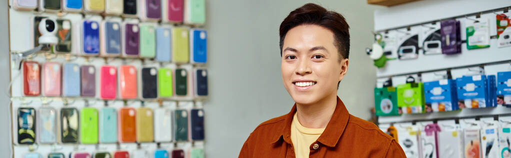 mosolygós sikeres ázsiai vállalkozó nézi kamera privát elektronikai bolt, banner - Fotó, kép