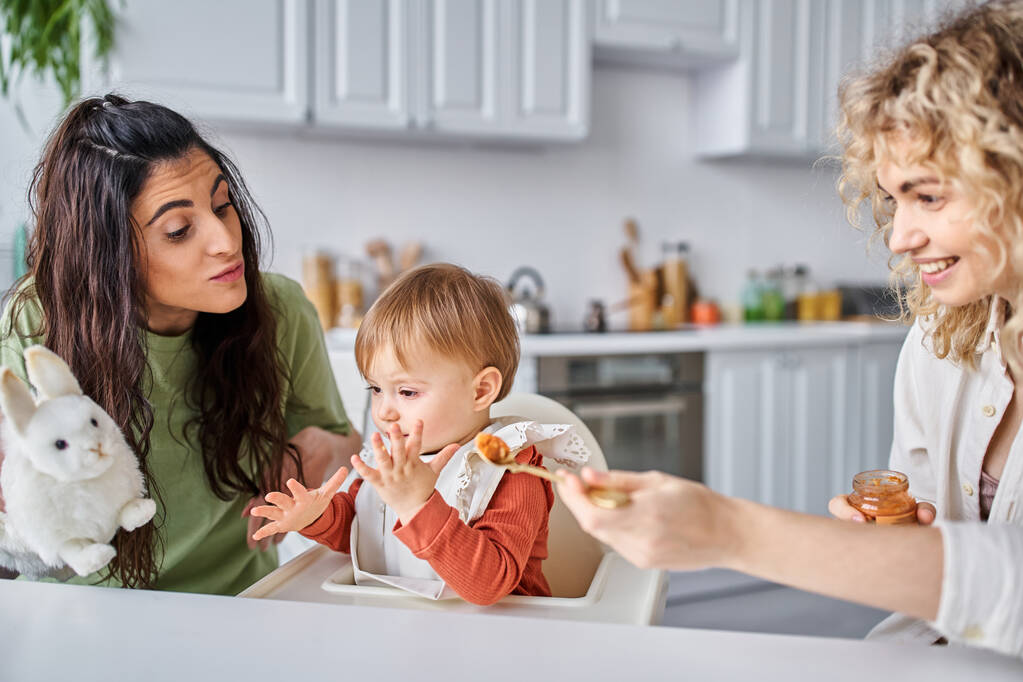 alegre unido pareja lesbiana teniendo sabroso desayuno con su bebé niña, concepto de familia - Foto, imagen