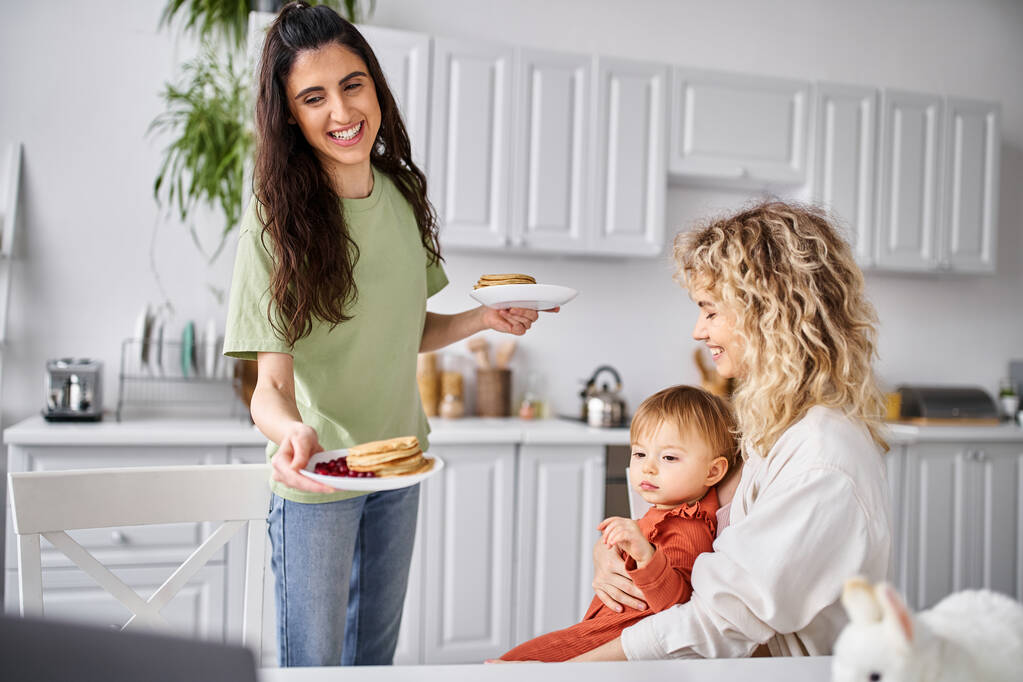 hermosa feliz lesbiana pareja teniendo panqueques en el desayuno con su bebé niña, concepto de familia - Foto, Imagen
