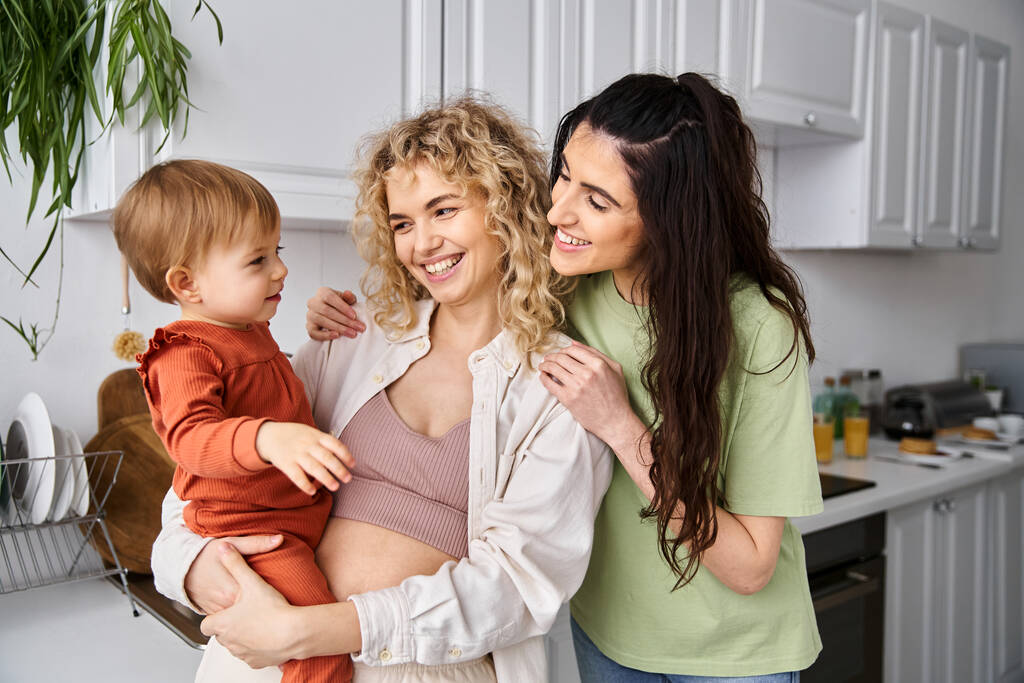 kaunis iloinen lesbo pari homewear poseeraa onnellisesti heidän vauva tyttö, moderni vanhemmuus - Valokuva, kuva