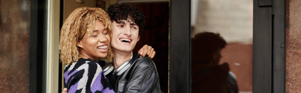 heureux couple diversifié en tenue décontractée étreignant par l'entrée du café végétalien, bannière de date de café - Photo, image
