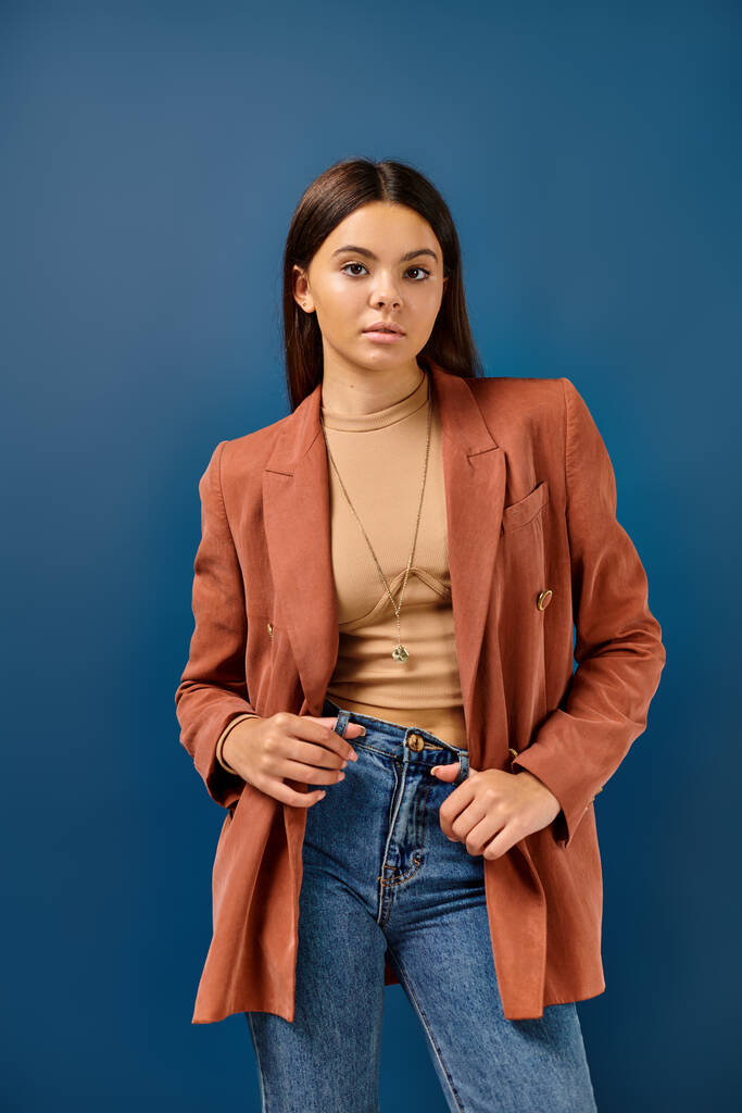 adorable stylish adolescent girl in brown elegant blazer posing and looking straight at camera - Photo, Image