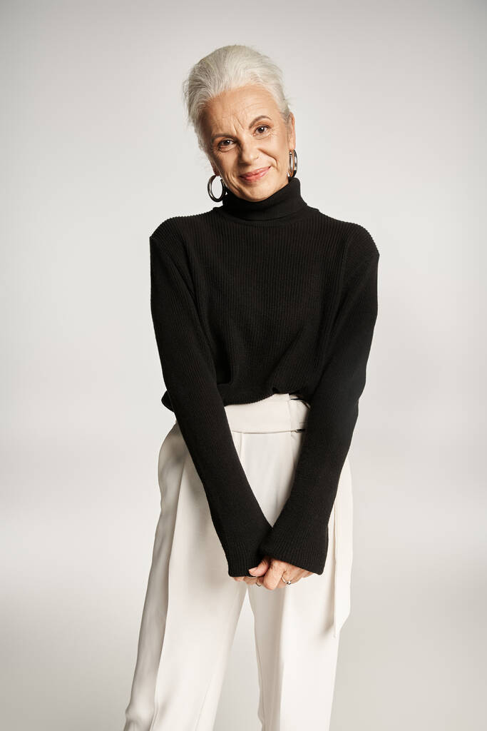 щаслива бізнес-леді середнього віку в стильному розумному повсякденному вбранні позує на сірому фоні, елегантна - Фото, зображення