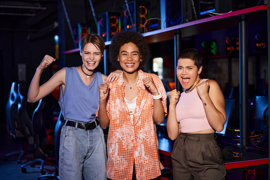 Las mujeres con ropa de moda comparten un momento de alegría mientras se regocijan en el club de ciberdeporte, amigos - Foto, imagen