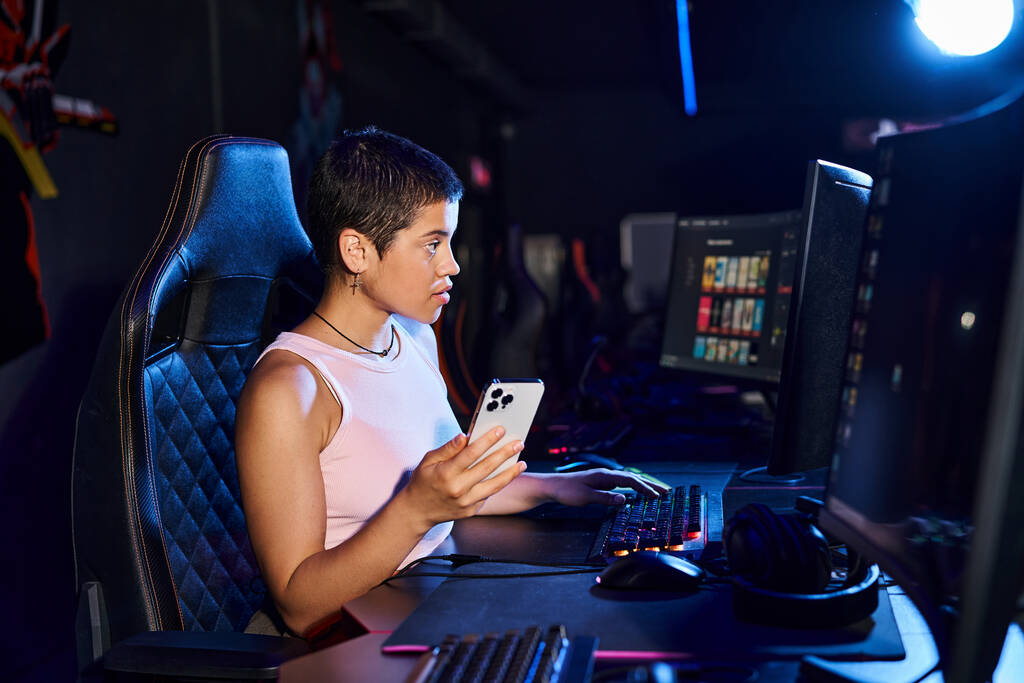 Een vrouw, gekleed in casual kleding, zitten aandachtig aan haar bureau, haar focus gericht op computerscherm - Foto, afbeelding