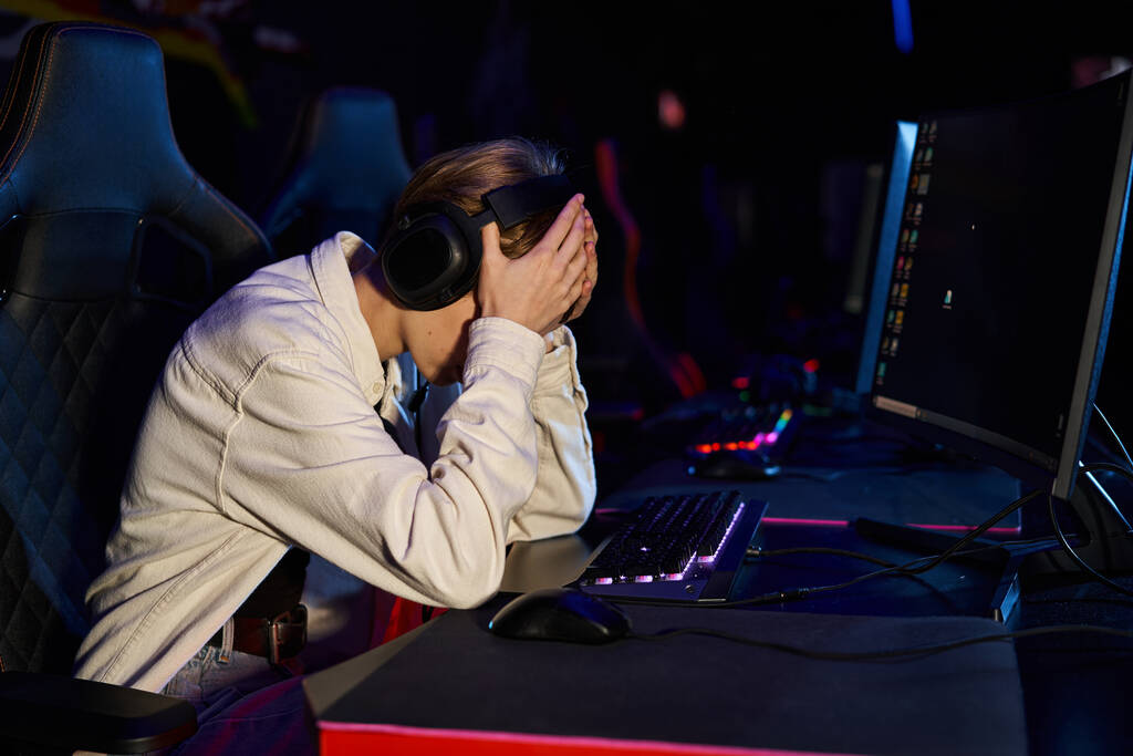 gamer molesto en los auriculares con las manos en la cara después de un partido de ciberdeporte perdedor, decepción - Foto, Imagen