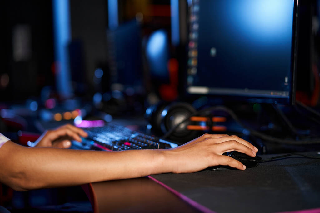 обрізаний знімок жінки за допомогою комп'ютерної миші біля освітленої клавіатури під час гри, кіберспорт - Фото, зображення