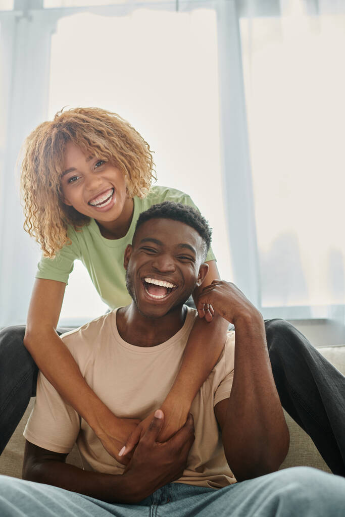 alegre afroamericana mujer abrazando novio en sala de estar, negro pareja y calidad de tiempo - Foto, imagen