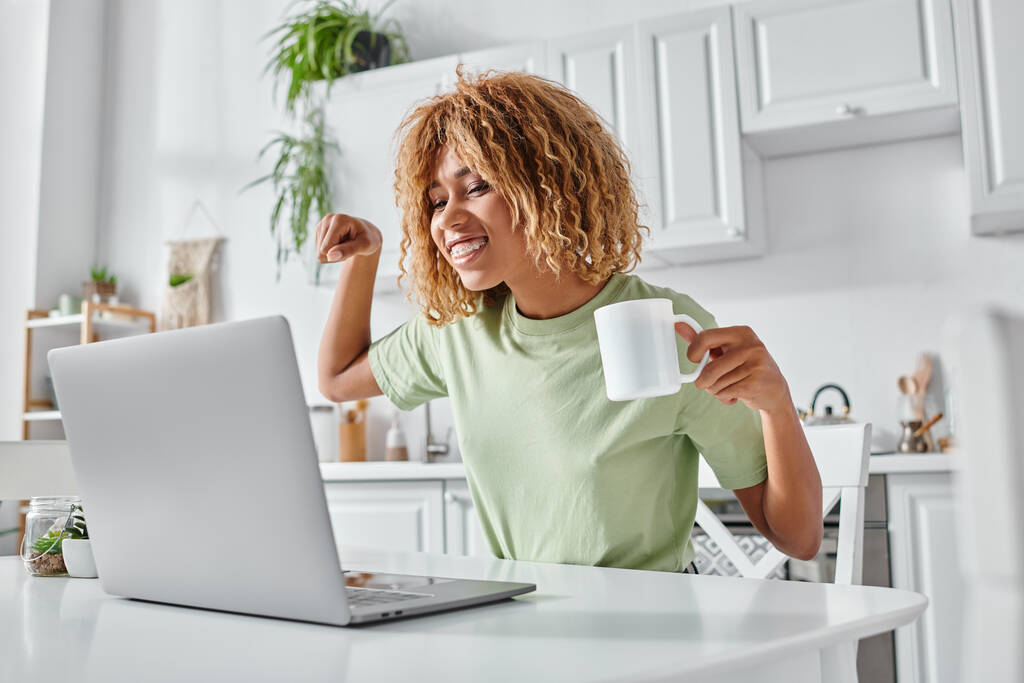 happy african american woman using sign language during video call and holding cup, nonverbal - Photo, Image