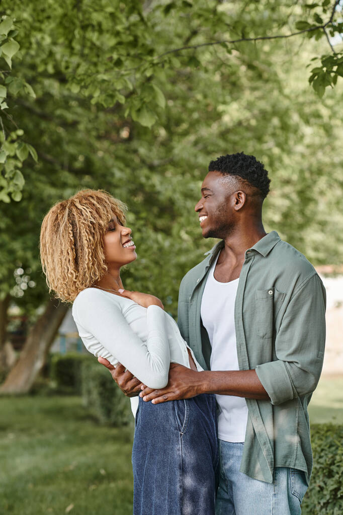 アフリカ系アメリカ人のカップルは笑い,アウトドアでお互いを抱き合って,黒人女性は勇敢で男 - 写真・画像