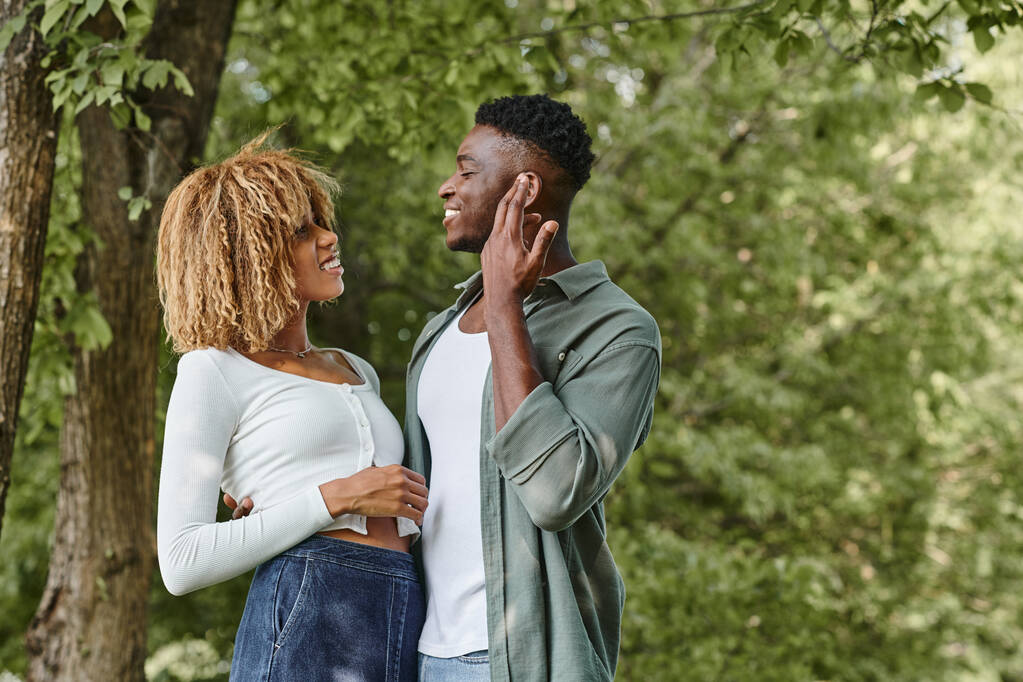 νοηματική γλώσσα, χαρούμενο αφρικανικό ζευγάρι που επικοινωνεί με χειρονομίες και στέκεται σε εξωτερικούς χώρους - Φωτογραφία, εικόνα